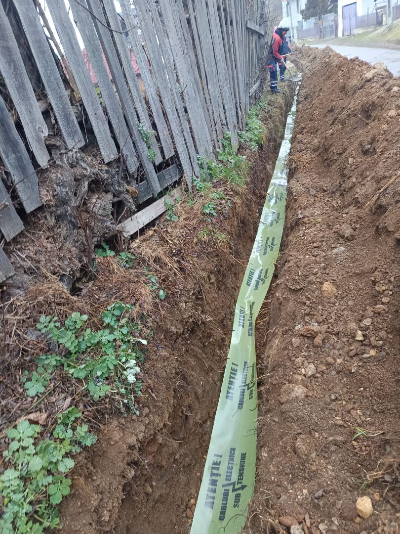 Instalarea benzii de avertizare verde Atentie cabluri sub tensiune in sant